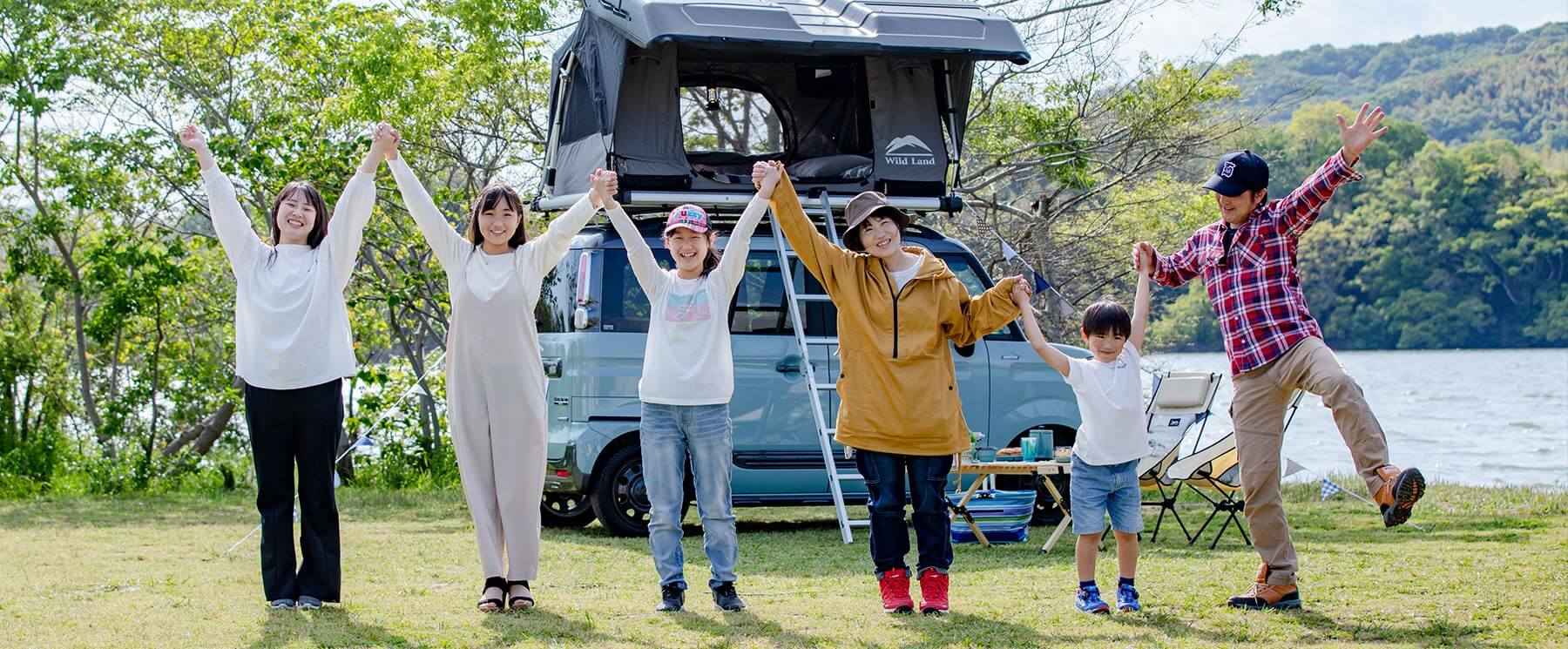 ニーズジャパン 家族集合写真 ルーフテントをバックに笑顔で手をつなぐ