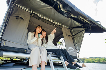 ルーフテントから景色を眺める2人の女性