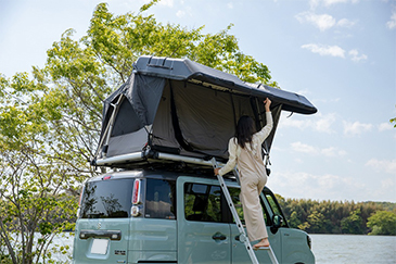 ルーフテントをたたむ人